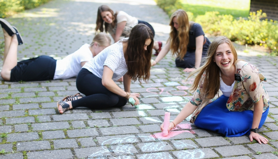 Missionarinnen der Kirche Jesu Christi malen mit Kreide auf der Straße.