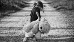 Zu sehen ist ein junges Mädchen, die ein riesiges Kuscheltier in der Hand hält und sich etwas wegdreht. Kinder haben auch einen emotionalen Hunger, der ebenso befriedigt werden muss, wie der nach Nahrung.