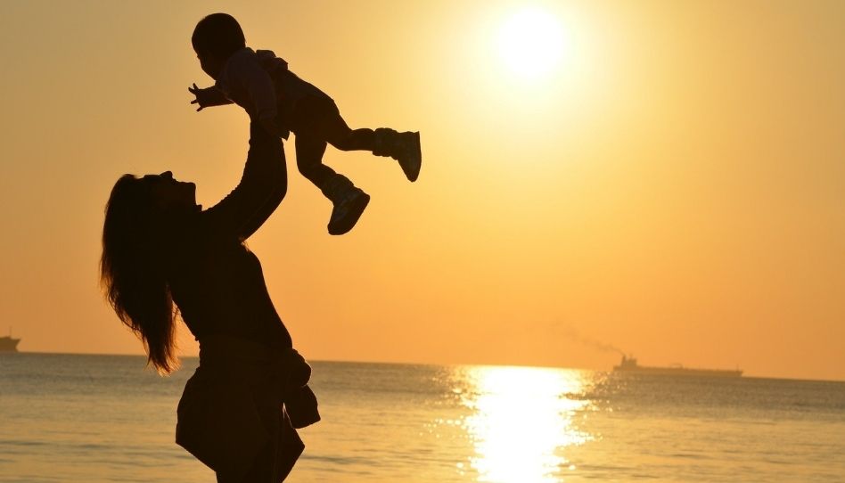 Eine Mutter hält ihr Baby in die Luft