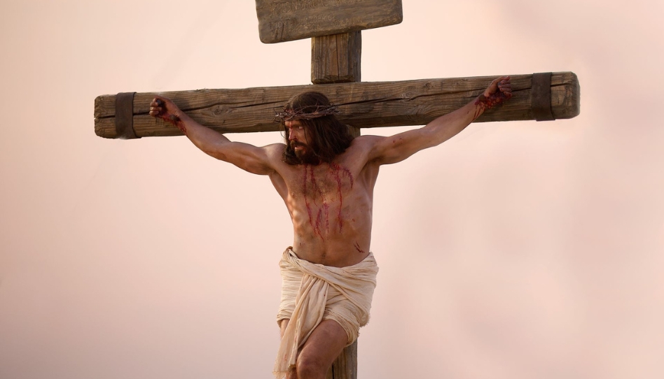 Jesus Christus hängt, mit einer Dornenkrone, am Kreuz und schaut zur Seite. Blut läuft von verschiedenen Wunden über seinen Körper.