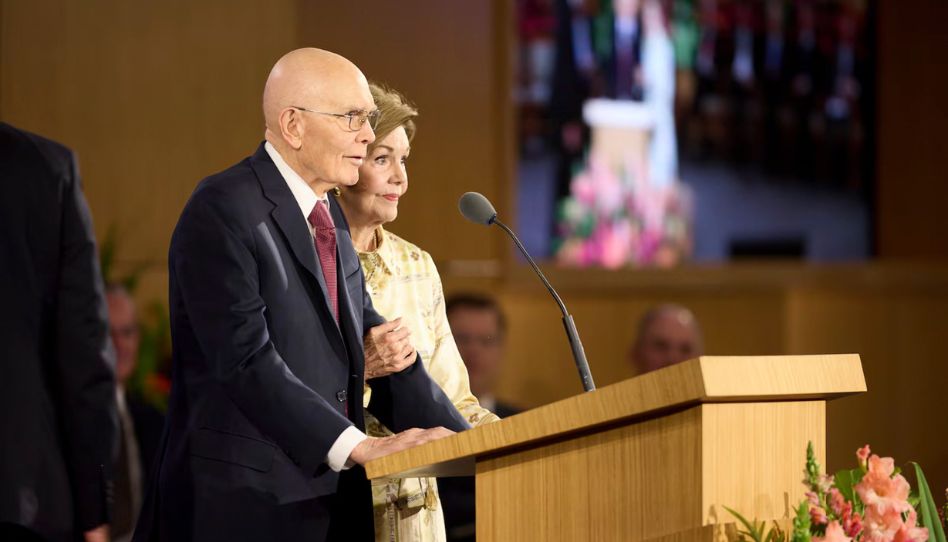 Präsident Oaks und seine Frau Kristen am Rednerpult