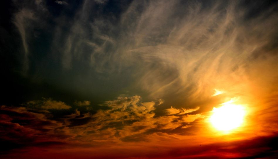 Ein wunderschöner Abendhimmel – mit der Sonne und Farben von dunkel blau bis dunkel rot.