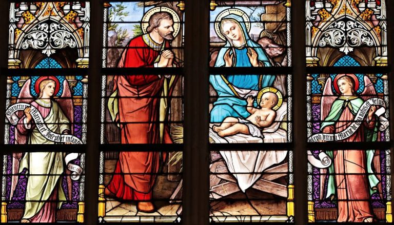 Kirchenfenster mit Maria, Josef und dem Jesuskind, umgeben von zwei Engeln
