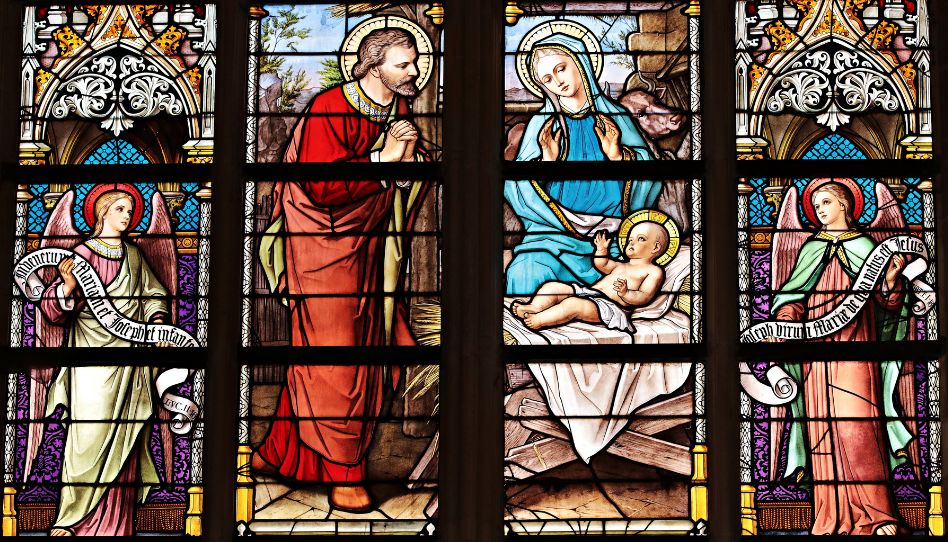 Kirchenfenster mit Maria, Josef und dem Jesuskind, umgeben von zwei Engeln